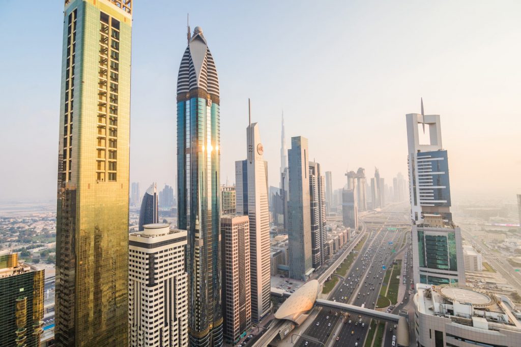 Panorámica de Dubái con rascacielos y la autopista Sheikh Zayed al atardecer.