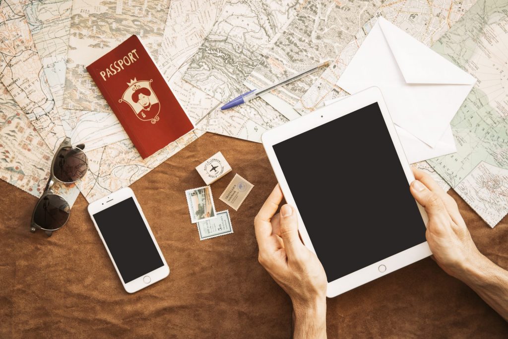 Pasaporte, mapas y tablet junto a una lista en inglés para trámites de aduanas